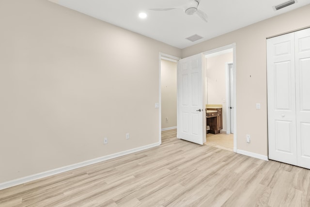 unfurnished bedroom with ceiling fan, a closet, ensuite bathroom, and light hardwood / wood-style flooring