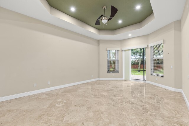 home theater room featuring a raised ceiling and carpet floors