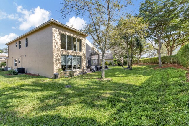 exterior space featuring central AC and a yard