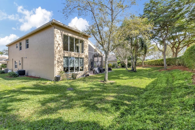 view of side of home featuring central AC unit and a lawn