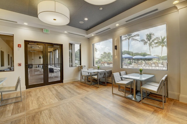 interior space with wood-type flooring, french doors, and a raised ceiling