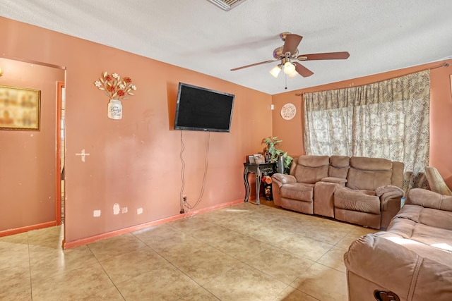 tiled living room with a textured ceiling and ceiling fan