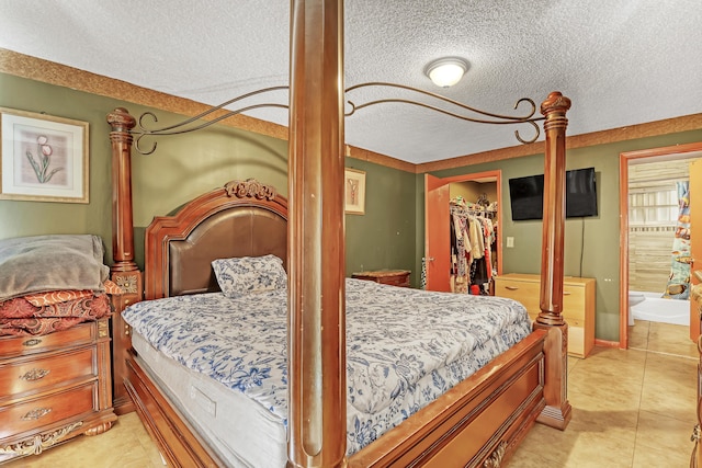 bedroom featuring a textured ceiling, a spacious closet, and a closet