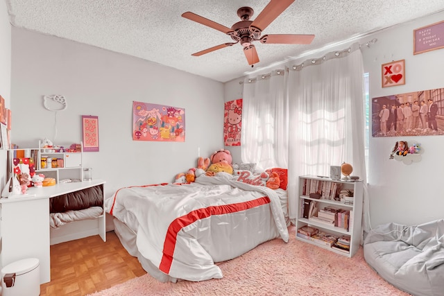 bedroom with parquet flooring, a textured ceiling, and ceiling fan