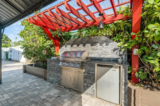 view of patio featuring a pergola, area for grilling, and exterior kitchen