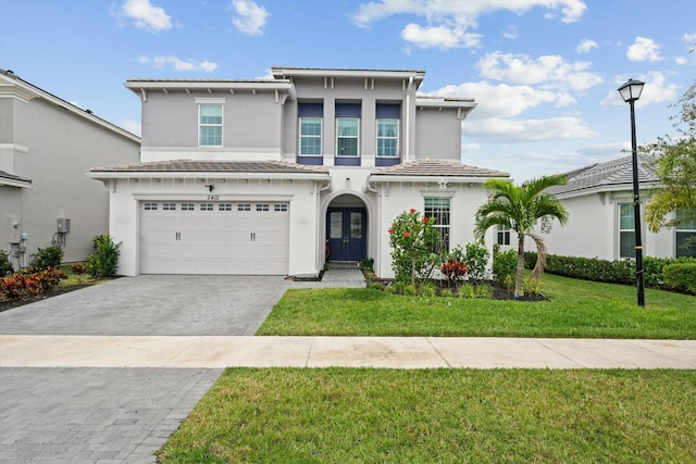 view of front of home with a front lawn, a garage, and french doors