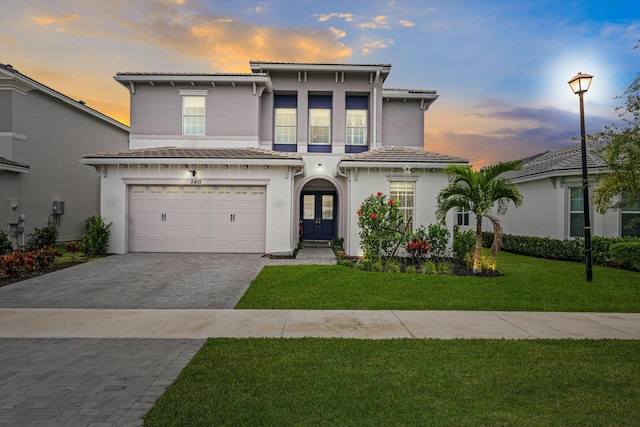 view of front of home featuring a lawn, french doors, and a garage