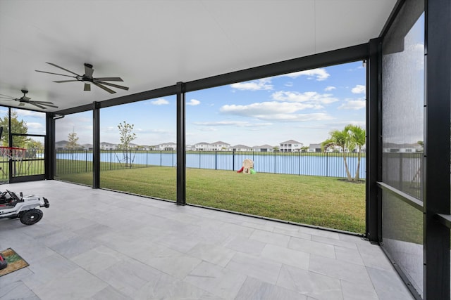 unfurnished sunroom with ceiling fan and a water view