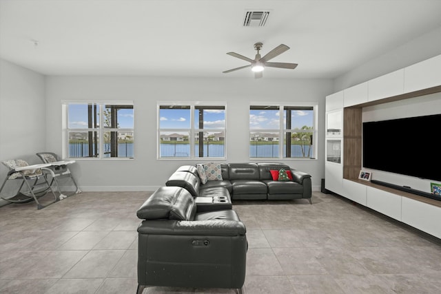 living room featuring ceiling fan, light tile patterned floors, visible vents, and baseboards