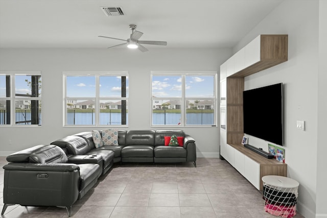 living room with light tile patterned floors, plenty of natural light, visible vents, and baseboards