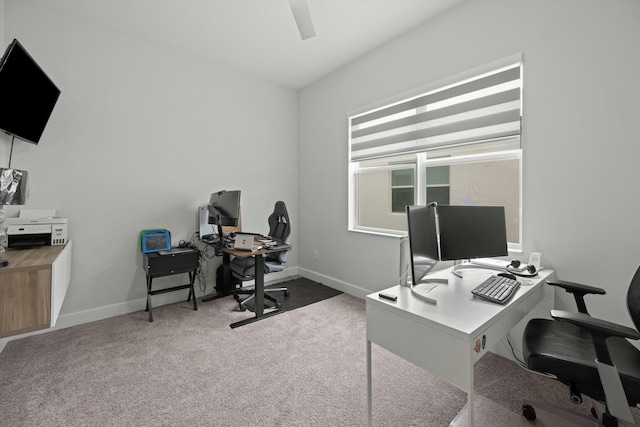 office area with dark colored carpet, a ceiling fan, and baseboards