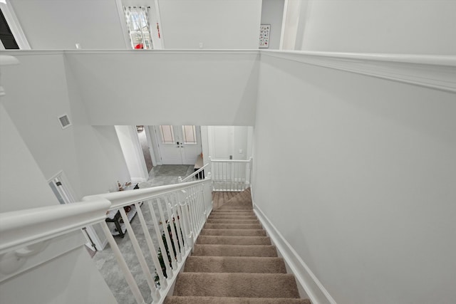 staircase with visible vents and baseboards