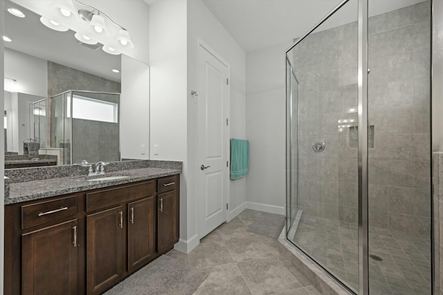 bathroom featuring baseboards, a shower stall, and vanity