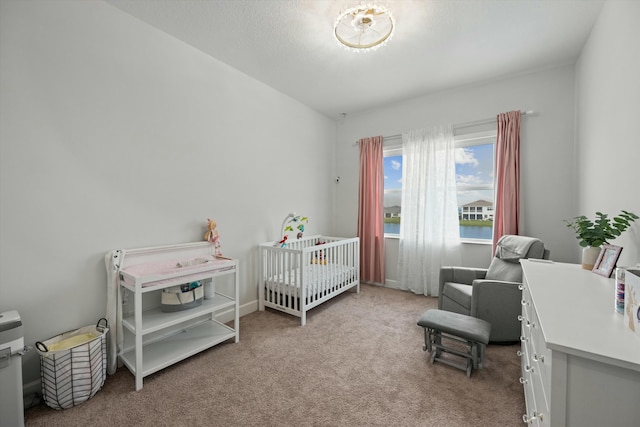 bedroom with a crib and light colored carpet