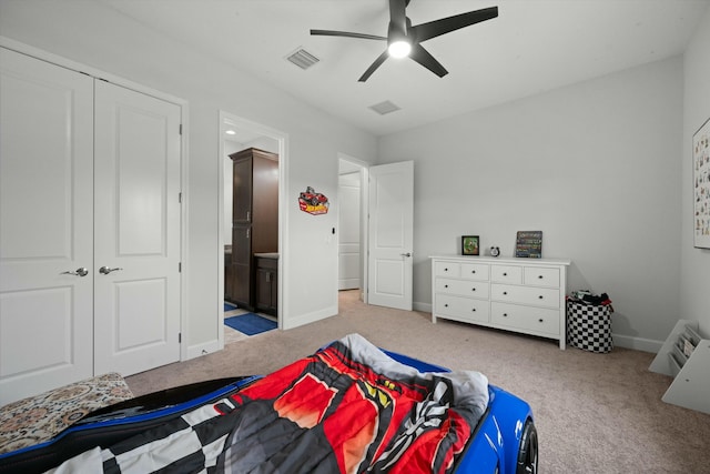 carpeted bedroom with ensuite bath, a closet, and ceiling fan