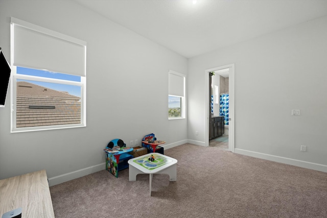 game room with light colored carpet and baseboards