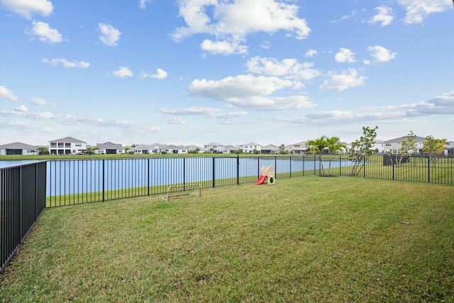 view of yard with a water view, a fenced backyard, and a residential view