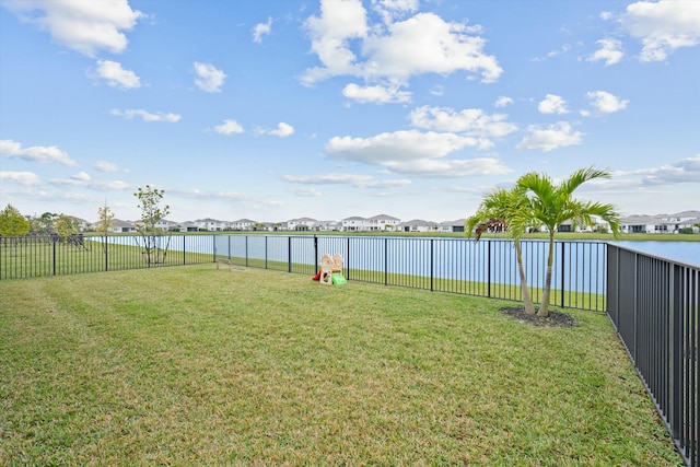 view of yard featuring a water view, a fenced backyard, and a residential view