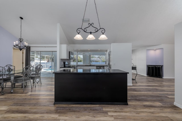 kitchen with hanging light fixtures, hardwood / wood-style floors, a chandelier, white cabinets, and appliances with stainless steel finishes