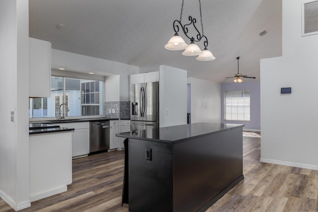 kitchen with ceiling fan, white cabinets, stainless steel appliances, and decorative light fixtures