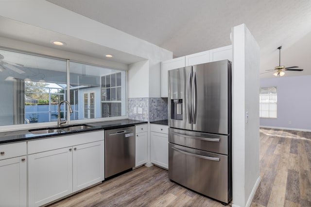 kitchen with tasteful backsplash, white cabinetry, sink, and appliances with stainless steel finishes