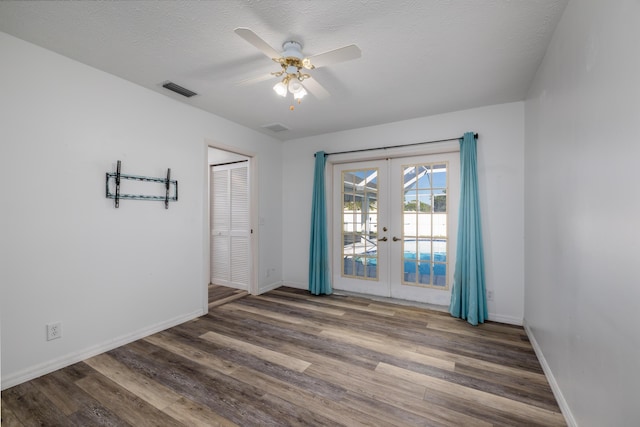 unfurnished room featuring ceiling fan, dark hardwood / wood-style flooring, a textured ceiling, and french doors