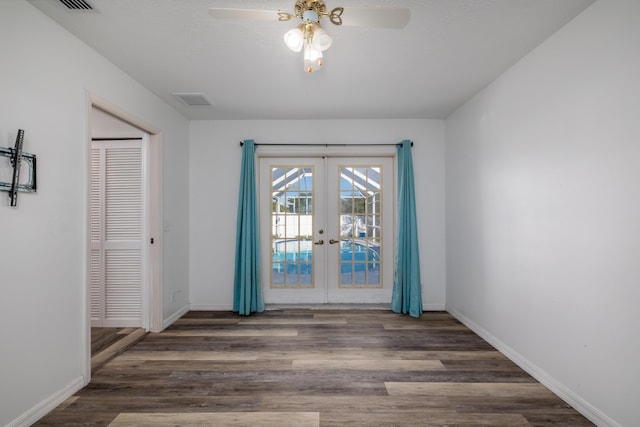 empty room with french doors, dark hardwood / wood-style flooring, and ceiling fan