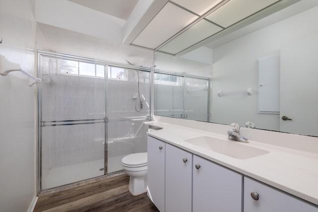 bathroom featuring walk in shower, toilet, vanity, and hardwood / wood-style flooring