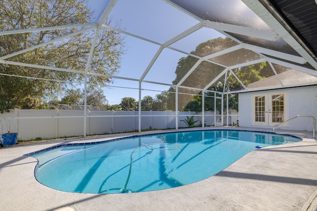 view of pool with glass enclosure, a patio, and french doors