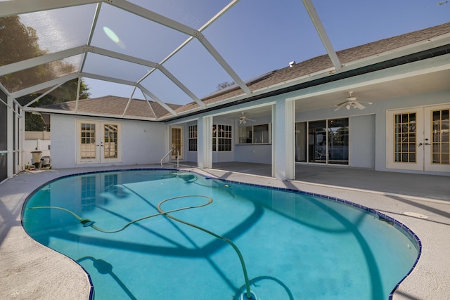 view of pool featuring glass enclosure, ceiling fan, french doors, and a patio area