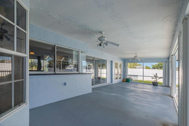 unfurnished sunroom featuring ceiling fan