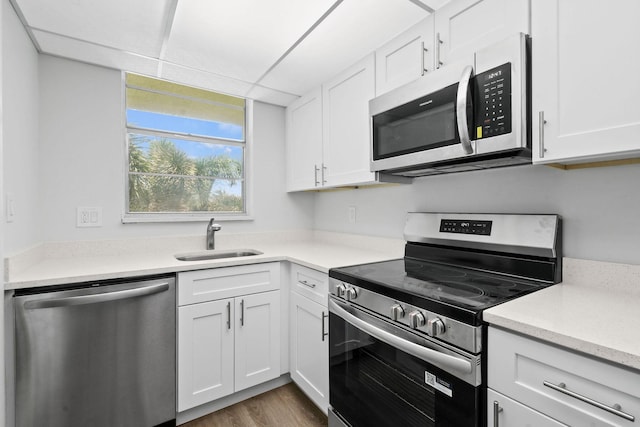 109 Paradise Harbour Blvd Unit 309, North Palm Beach, FL 33408 - kitchen featuring stainless steel appliances, light countertops, white cabinetry, and wood finished floors