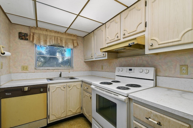 kitchen with light brown cabinetry, sink, and white appliances