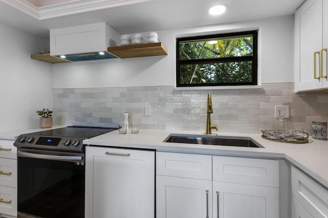 kitchen with tasteful backsplash, electric range, sink, and white cabinets