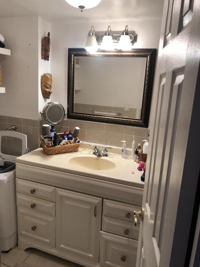 bathroom with backsplash, tile patterned floors, vanity, and tile walls