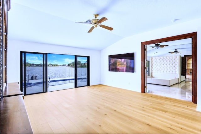 empty room with light hardwood / wood-style flooring and lofted ceiling