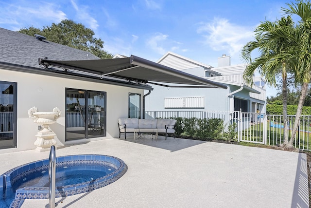 back of house with an in ground hot tub and a patio