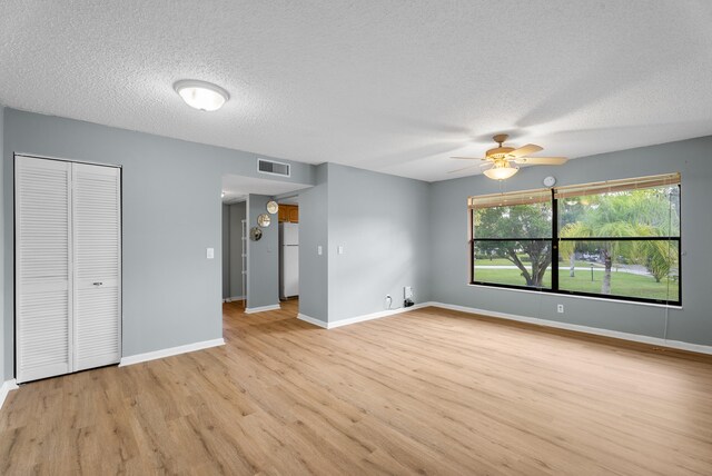 151 SW S River Dr Unit 203, Stuart, FL 34997 - unfurnished bedroom with freestanding refrigerator, light wood-style flooring, a textured ceiling, a closet, and ceiling fan