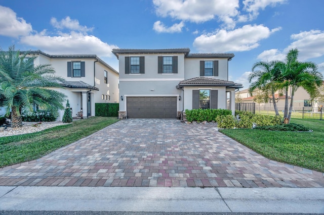 mediterranean / spanish house featuring a garage and a front lawn