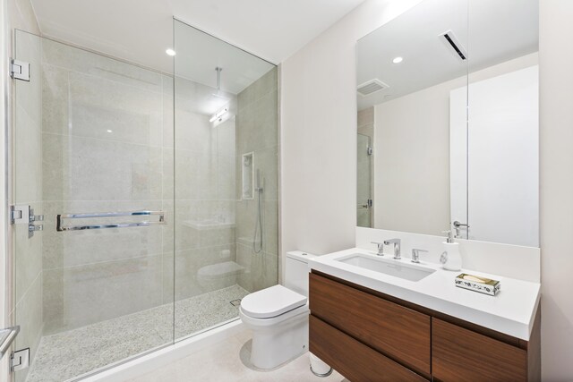 bathroom with tile patterned flooring, vanity, toilet, and walk in shower