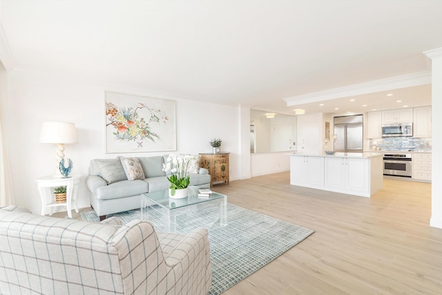 living room with light hardwood / wood-style flooring and ornamental molding