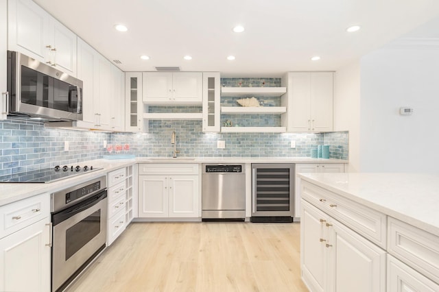 kitchen featuring sink, wine cooler, decorative backsplash, appliances with stainless steel finishes, and white cabinetry