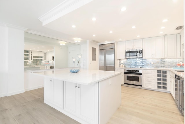 kitchen featuring light stone countertops, white cabinetry, a center island, and stainless steel appliances