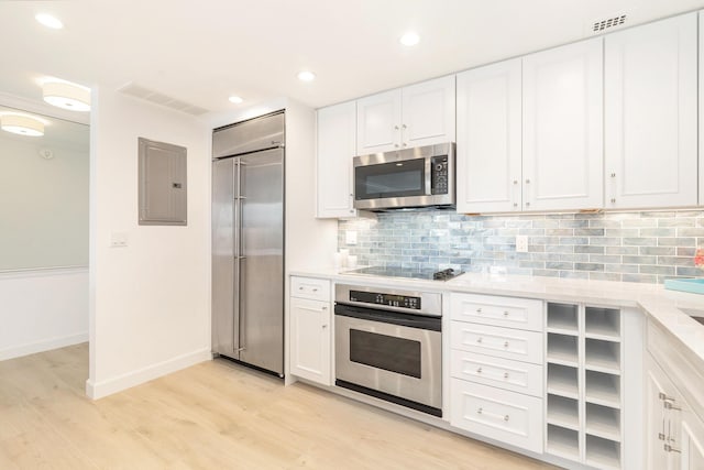 kitchen with backsplash, stainless steel appliances, light hardwood / wood-style flooring, electric panel, and white cabinetry