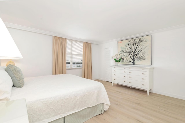 bedroom featuring ornamental molding and light hardwood / wood-style flooring