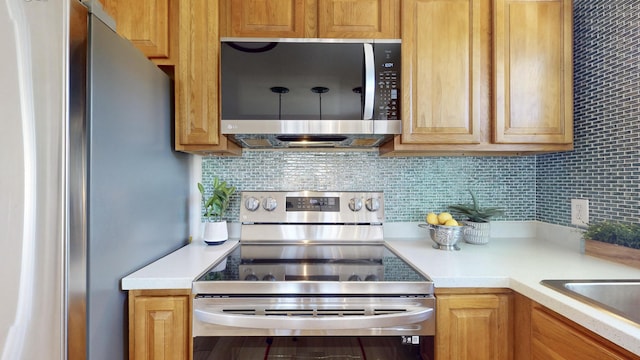 kitchen with tasteful backsplash, sink, and appliances with stainless steel finishes