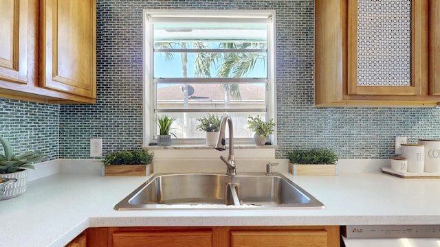 kitchen featuring decorative backsplash, dishwasher, and sink