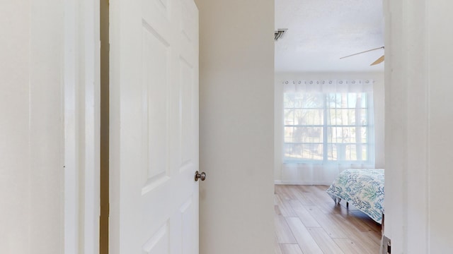 bathroom with hardwood / wood-style floors, a textured ceiling, and ceiling fan