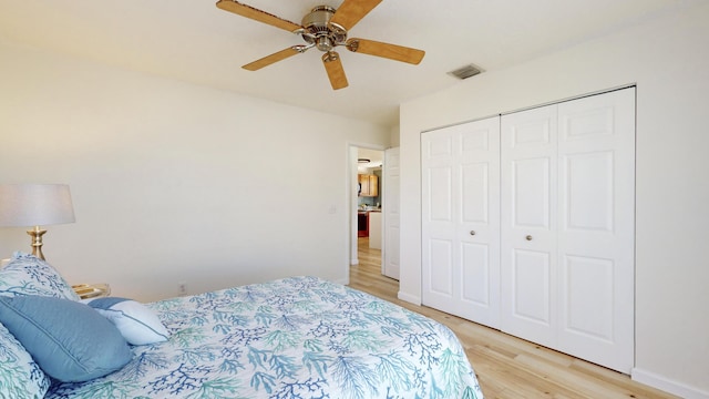 bedroom with ceiling fan, light wood-type flooring, and a closet