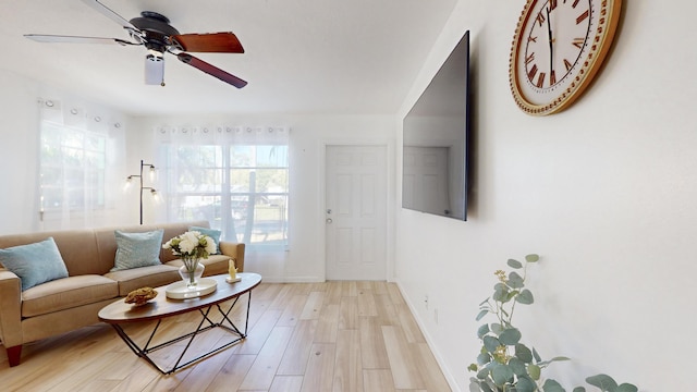 living room featuring light hardwood / wood-style flooring and ceiling fan